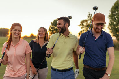 Vier Personen mit Golfschlägern auf einem Golfplatz